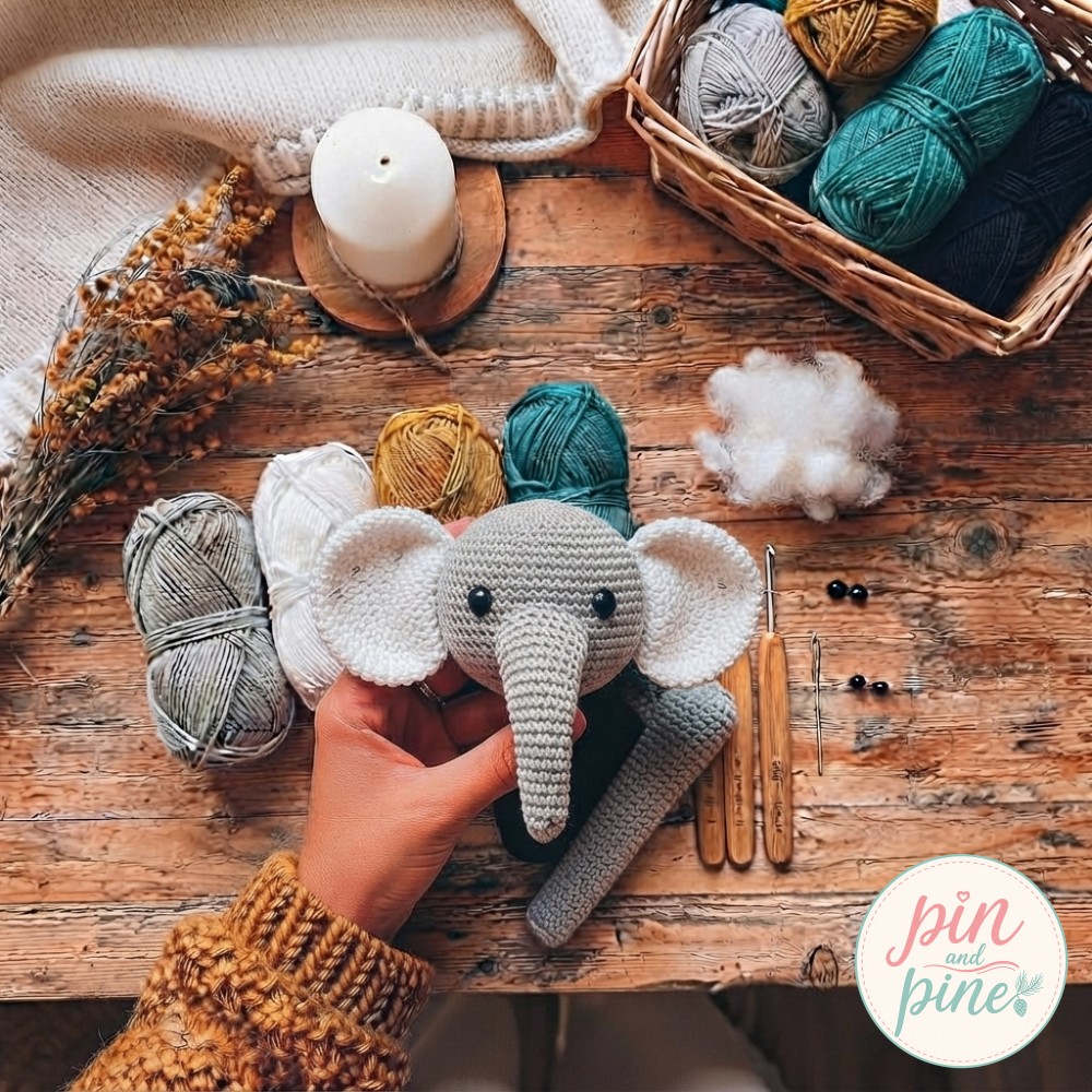 White ears pinned to the crochet elephant amigurumi head with the trunk now sewn onto the face