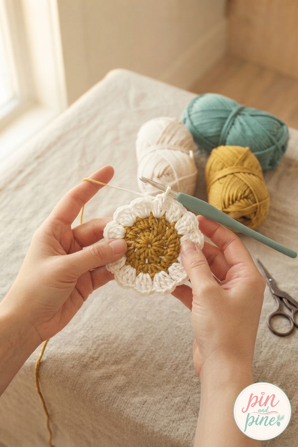 Close-up of white petal stitches worked around a mustard center in this crochet flower blanket pattern