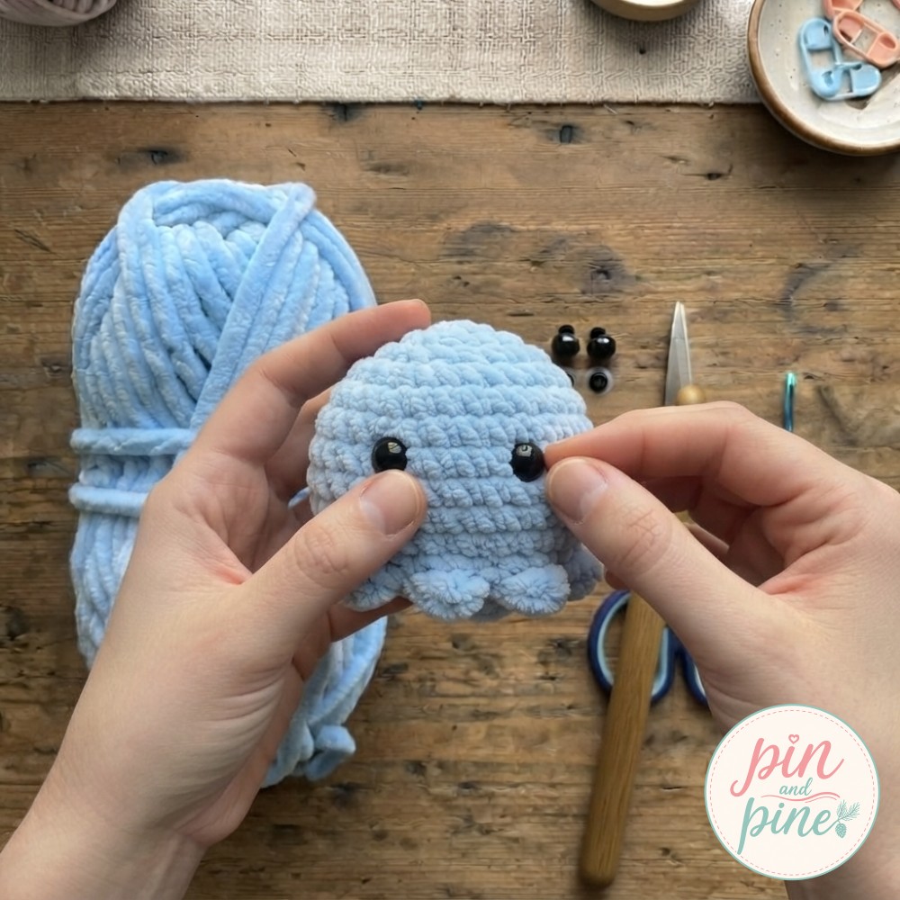 Pressing black safety eyes into the stuffed head brings this mini crochet octopus to life.