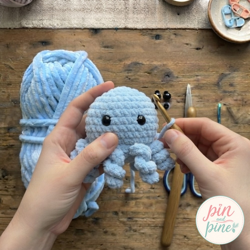 Eight short tentacles curling into place as the mini crochet octopus nears completion.